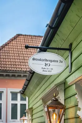 a sign hanging on the side of a house at Bryggen Living in Bergen