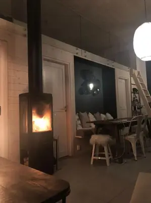 a living room with a fireplace and a table and chairs at Delikat hytte omgitt av Hallingdals vakre fjell in Ål