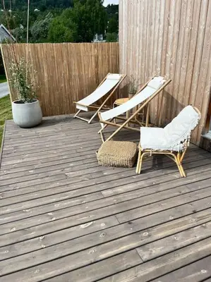 two chairs on a wooden deck with a fence at Delikat hytte omgitt av Hallingdals vakre fjell in Ål
