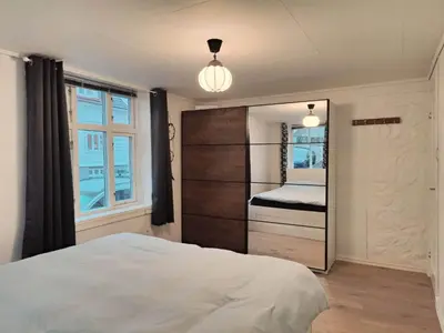 a bedroom with a large bed and a window at Fløyen Townhouse in Bergen