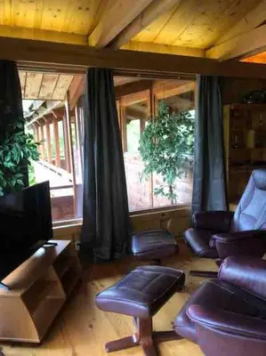 a living room with leather chairs and a tv at Olden by the fjords of Norway, Bjørkelund in Stryn