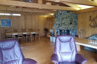 a living room with chairs and a stone fireplace at Olden by the fjords of Norway, Bjørkelund in Stryn
