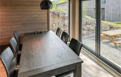 a table and chairs in a room with a large window at Nice Home In Edland With Wifi