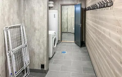 a bathroom with a hallway with a toilet and a door at Nice Home In Edland With Wifi
