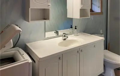 a bathroom with a white sink and a toilet at 2 Bedroom Cozy Home In Lauvstad in Lauvstad