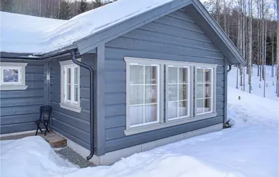 a blue house with windows in the snow at Gorgeous Home In Noresund With Wifi in Noresund