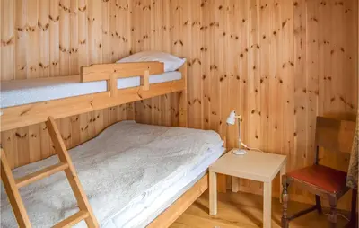 a bedroom with two bunk beds and a chair at Gorgeous Home In Noresund With Wifi in Noresund