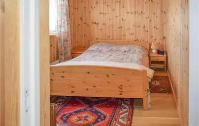 a bedroom with a bed in a wooden room at Gorgeous Home In Noresund With Wifi in Noresund