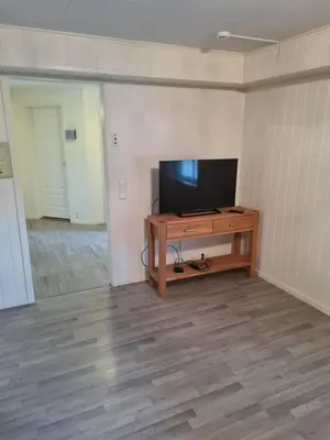 a room with a television and a wooden table at Fjærland Våteviksvegen 17 in Bøyum