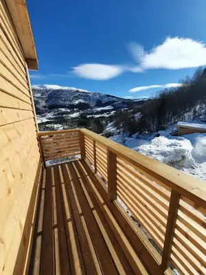 a wooden deck with a view of a snowy mountain at Molden 2-fjellutsikt og jacuzzi tilgang. in Luster
