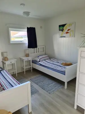 a small bedroom with two beds and two tables at Holiday Apartment in Flatanger in Vik