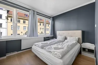 a bedroom with a bed and two windows at 2 min to Bryggen - Rooftop - Office with 49