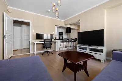a living room with a television and a table at 2 min to Bryggen - Rooftop - Office with 49