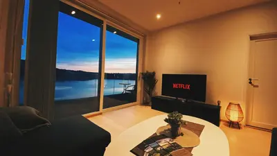 a living room with a table and a large window at MJOS TOWER Suite - Lovely lake view in Brumunddalen