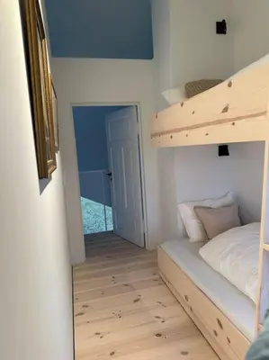 a small room with a bunk bed and a ladder at Storlauvøya The Atlantic Ocean Road in Karvåg