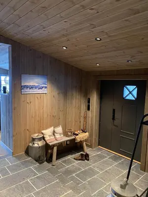 a room with a wooden wall with a bench and a door at New mountain lodge - Geilo-Kikut - Great location in Geilo