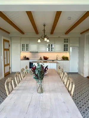a long table with chairs and a vase of flowers at Storsand Gård in Trondheim