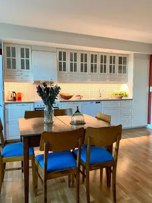 a kitchen with a wooden table and blue cabinets at Storsand Gård in Trondheim