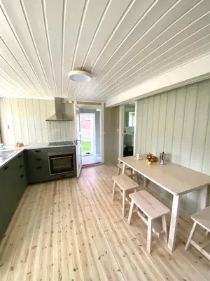 a kitchen with a table and chairs in a room at Storsand Gård in Trondheim