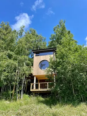 a house with a clock on the side of it at Fuglekassehytta in Sparbu