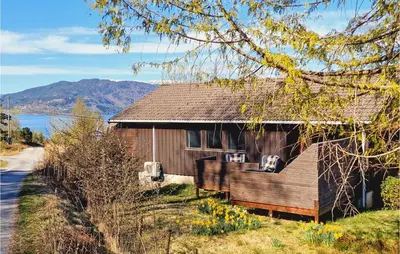 a wooden house with a view of a lake at Stunning Home In Skånevik With Kitchen in Skånevik