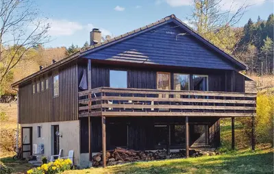 a large wooden house with a large deck at Stunning Home In Skånevik With Kitchen in Skånevik