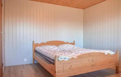 a bedroom with a wooden bed in a wall at Stunning Home In Skånevik With Kitchen in Skånevik