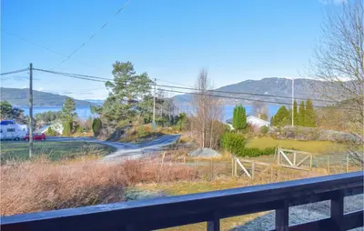 a train traveling down a road next to a fence at Stunning Home In Skånevik With Kitchen in Skånevik