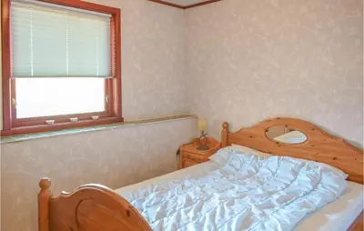a bedroom with a bed and a window at Stunning Home In Skånevik With Kitchen in Skånevik