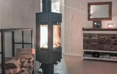 a wood burning stove in a room with a fireplace at Beautiful Home In Noresund With Wifi in Noresund