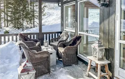 a screened porch with wicker chairs and a table at Beautiful Home In Noresund With Wifi in Noresund