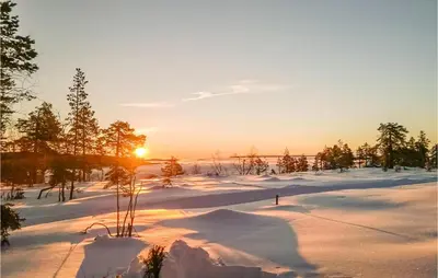 a snowy field with the sun setting in the background at Beautiful Home In Noresund With Wifi in Noresund