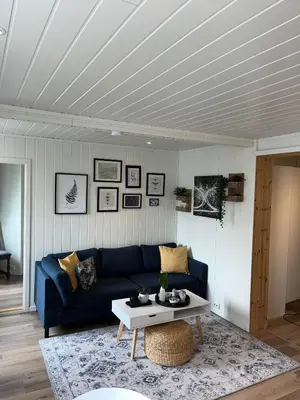 a living room with a blue couch and a table at Light home apartment Alesund with free parking in Ålesund