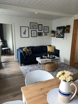 a living room with a blue couch and a table at Light home apartment Alesund with free parking in Ålesund
