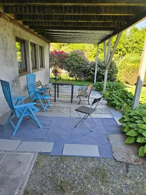 a patio with blue chairs and a table on it at Florvåg -flott utsikt mot byen in Florvåg
