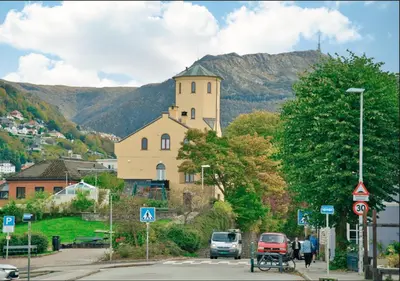 a building on the side of a street with a mountain at Bergen city center apartment in Bergen