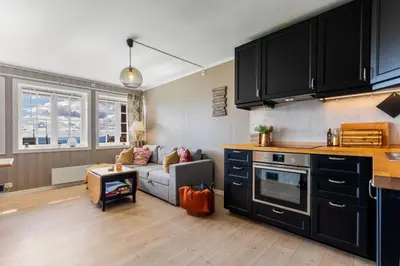 a kitchen and a living room with a couch at Bjødnabakkens innbydende in Beitostøl
