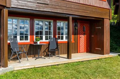 a cabin with a table and chairs on a deck at Bjødnabakkens innbydende in Beitostøl