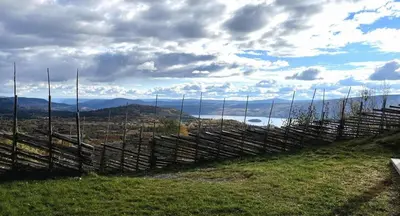 a fence on a hill with a view of the ocean at Bjødnabakkens innbydende in Beitostøl
