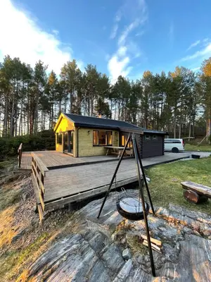 a home with a wooden deck and a house at A cottage by the forest with a sea view ! in Søfstad