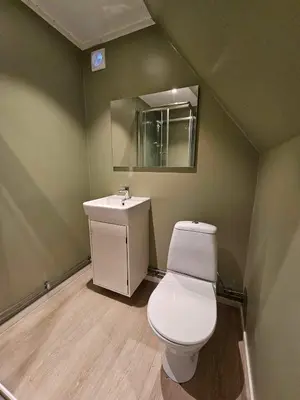 a bathroom with a white toilet and a sink at Leilighet med gratis parkering og WiFi in Kristiansund