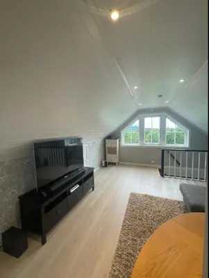 a living room with a piano in a room with a window at Leilighet med gratis parkering og WiFi in Kristiansund