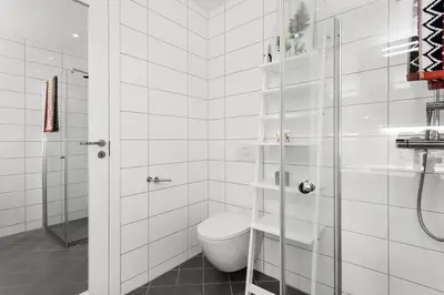a white bathroom with a toilet and a shower at Stor og moderne leilighet i Indre Arna Bergen GRATIS PARKERING!! in Bergen