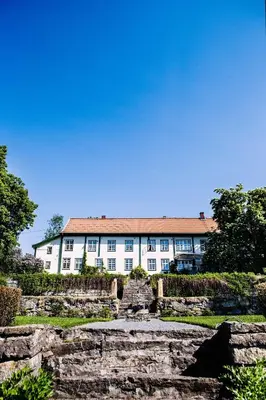 a large white building with a red roof at Hoel Gård - Herregården ved Mjøsa in Nes i Ådal