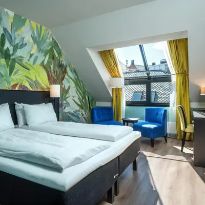 a hotel room with a bed and a chair at Thon Hotel Ålesund in Ålesund