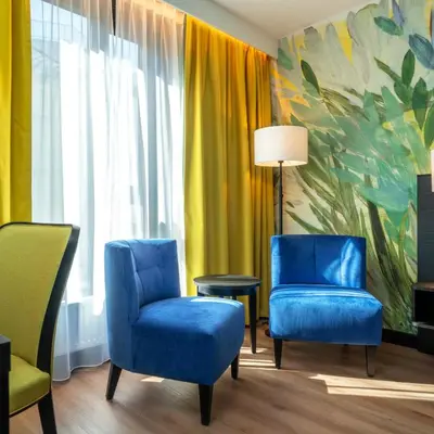two chairs and a table in a room with a painting at Thon Hotel Ålesund in Ålesund