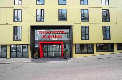 a yellow building with a red sign in front of it at Thon Hotel Ålesund in Ålesund