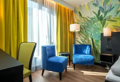 a room with two blue chairs and a painting at Thon Hotel Ålesund in Ålesund
