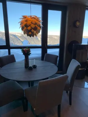 a dining room with a table and chairs and a large window at Gaustablikk Sportshytte midt i naturen in Rjukan