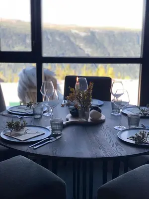 a table with a candle and plates and wine glasses at Gaustablikk Sportshytte midt i naturen in Rjukan